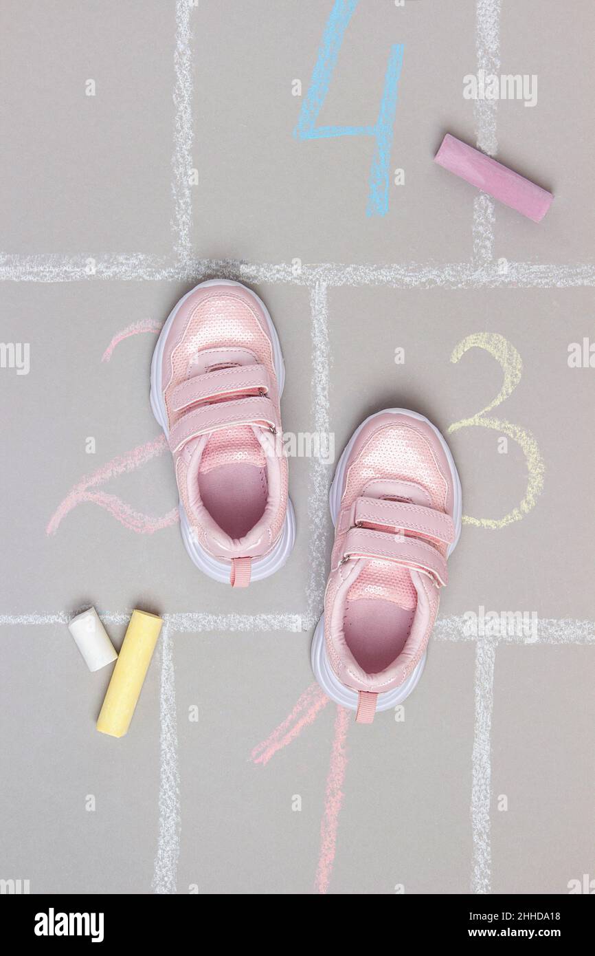 Rosa Sneakers und hopscotch Spiel. Draufsicht Flat Lay. Stockfoto