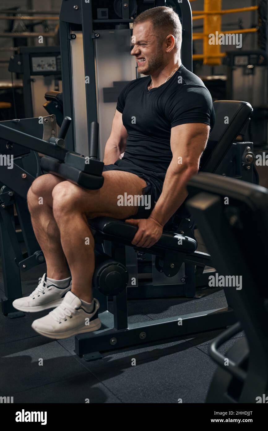 Männlicher Athlet, der an Fitnessgeräten arbeitet Stockfoto