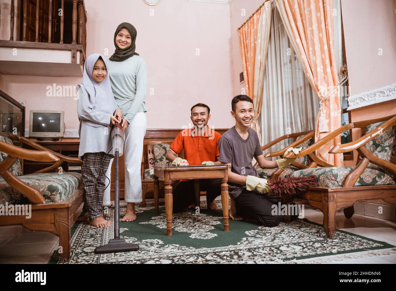 Alle asiatischen Familienmitglieder putzen das Familienzimmer zusammen Stockfoto