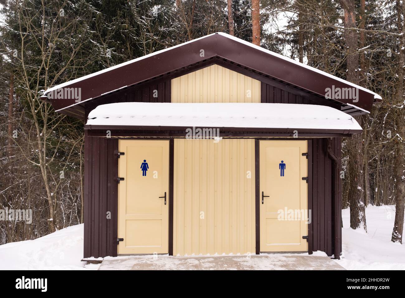 Toiletten für Männer und Frauen, die in einem verschneiten Wald stehen. Stockfoto