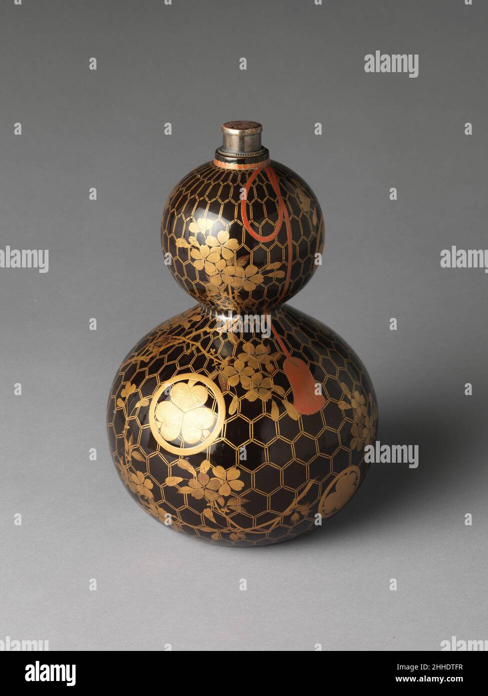Kürbis-förmige Sake-Flasche mit Kirschzweigen, Netz und Tokugawa-Familienwappen 18th. Jahrhundert Japan. Schürfförmige Sake-Flasche mit Kirschzweigen, Netz und Tokugawa-Familienwappen. Japan. 18th Jahrhundert. Lackiertes Holz mit Gold- und Silberhiramaki-e und rotem Lack. Edo-Zeitraum (1615–1868). Lack Stockfoto