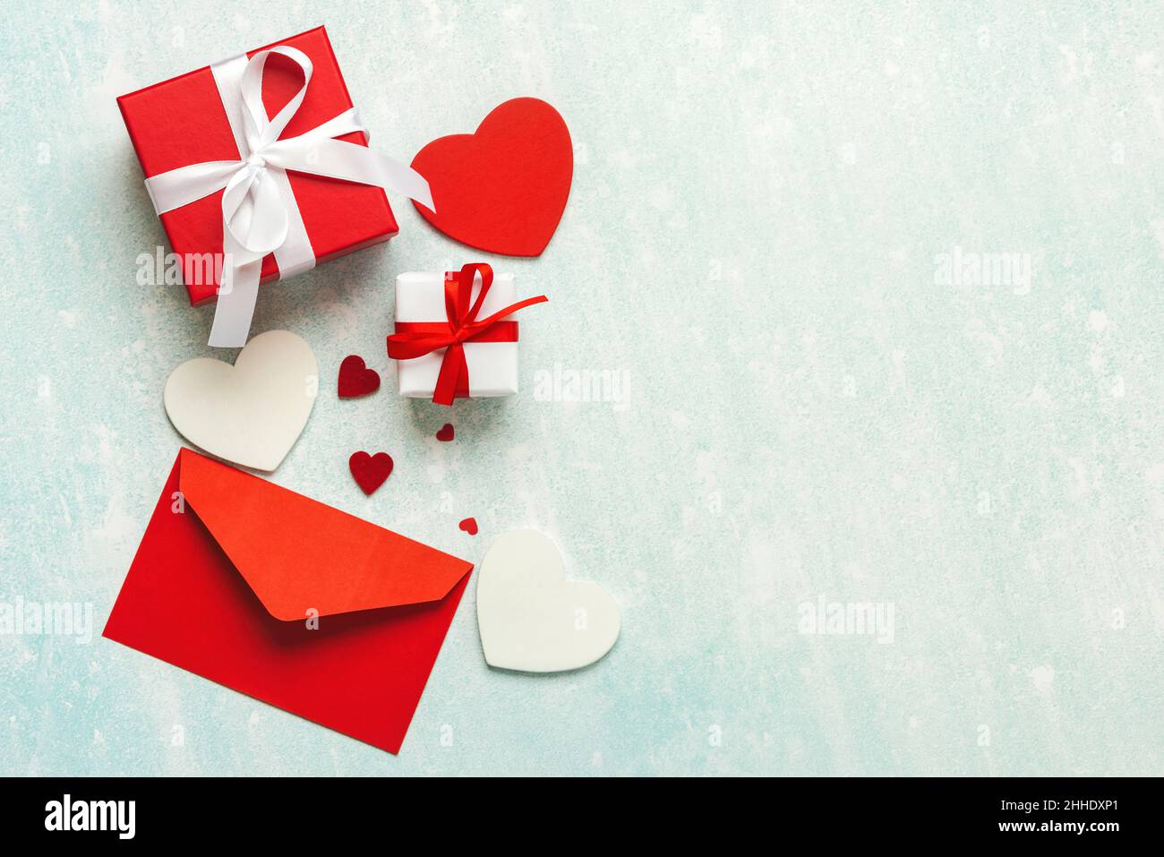 Draufsicht auf roten Umschlag, Herzen und Valentinstag Geschenkbox mit Kopieplatz auf blauem Hintergrund. Konzept für die Valentinstag-Feier Stockfoto