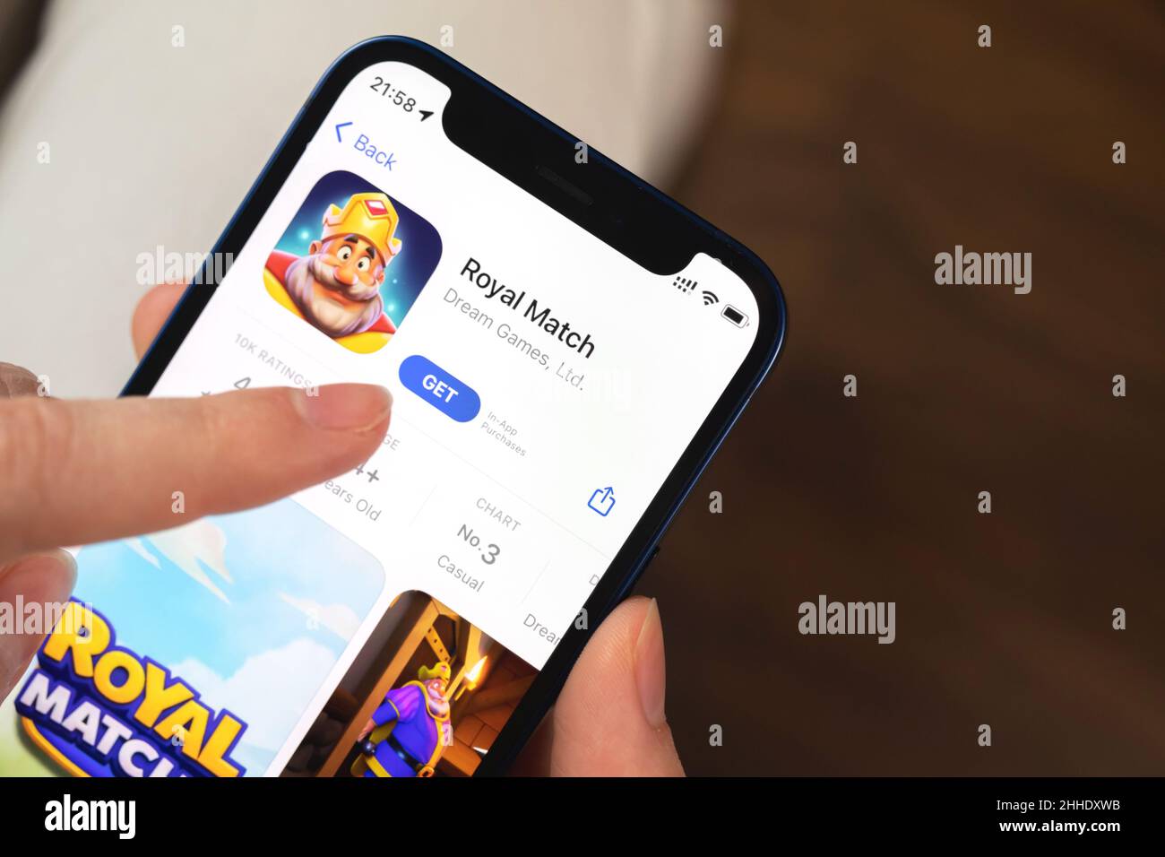 Charkow, Ukraine - 19. Januar 2022: Royal Match Spiel App. Mädchen hält Handy mit Spiel und wollen spielen. Beliebtes Konzept für mobile Spiele Stockfoto