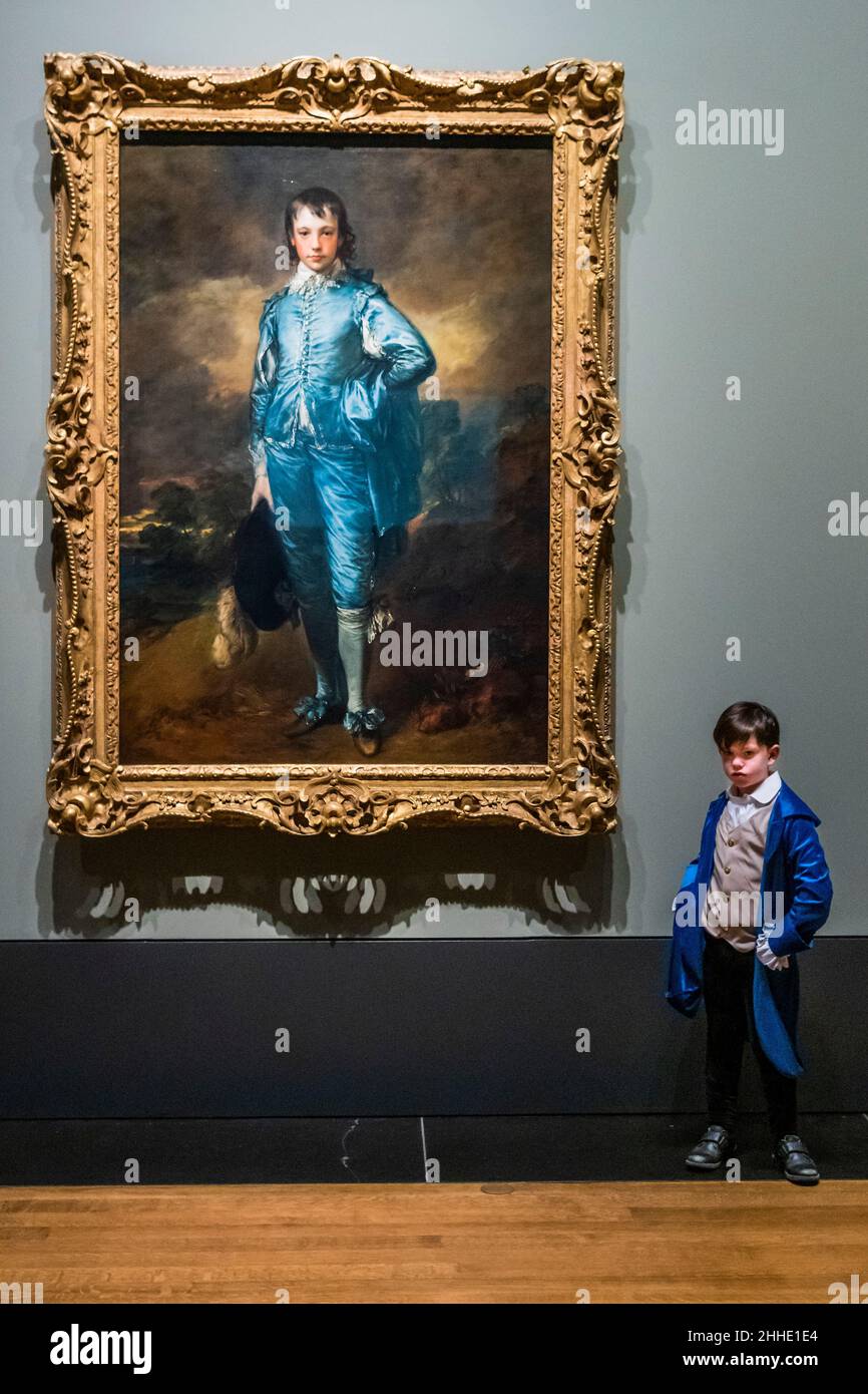 London, Großbritannien. 24th Januar 2022. The Blue Boy von Thomas Gainsborough erscheint in der National Gallery 100 Jahre, bis heute, seit es das letzte Mal im Land gesehen wurde. Foto mit Kindern von Mitarbeitern der National Gallery und der US-Botschaft in London. Das Werk gehört der Huntington Library, dem Kunstmuseum und den Botanischen Gärten in San Marino, Kalifornien. In der kostenlosen Ausstellung in Raum 46 wird der Blaue Junge neben einer ausgewählten Gruppe von fünf Gemälden gezeigt, die das anhaltende Interesse Gainsboroughs an Van Dycks Gemälden demonstrieren. Kredit: Guy Bell/Alamy Live Nachrichten Stockfoto