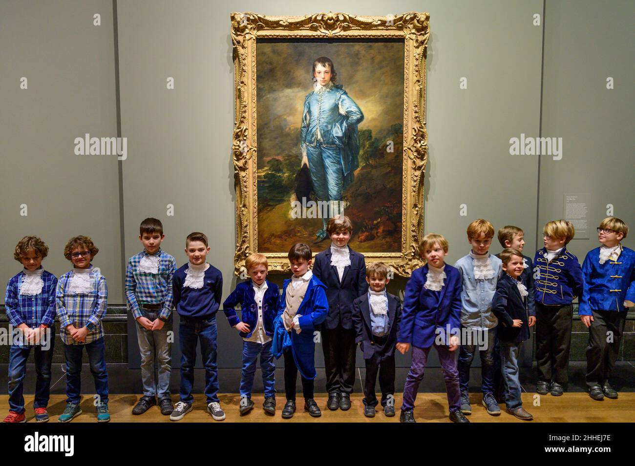 The National Gallery, London, Großbritannien. 24. Januar 2022. ‘The Blue Boy’, 1770, von Thomas Gainsborough wird zum 100th. Jahrestag seiner letzten Präsentation in Großbritannien in der National Gallery ausgestellt. Das Werk ist heute im Besitz der Huntington Library, des Art Museums und des Botanischen Gartens in San Marino, Kalifornien, wo es seit dem letzten Jahrhundert ausgestellt wird. Eine Gruppe ‘blauer Jungen’, Kinder von Mitarbeitern der National Gallery und der US-Botschaft in London, posieren vor dem Gemälde, alle in Blautönen gekleidet mit Kravatten, die der Figur auf dem Gemälde ähneln. Quelle: Malcolm Park/Alamy Live News. Stockfoto