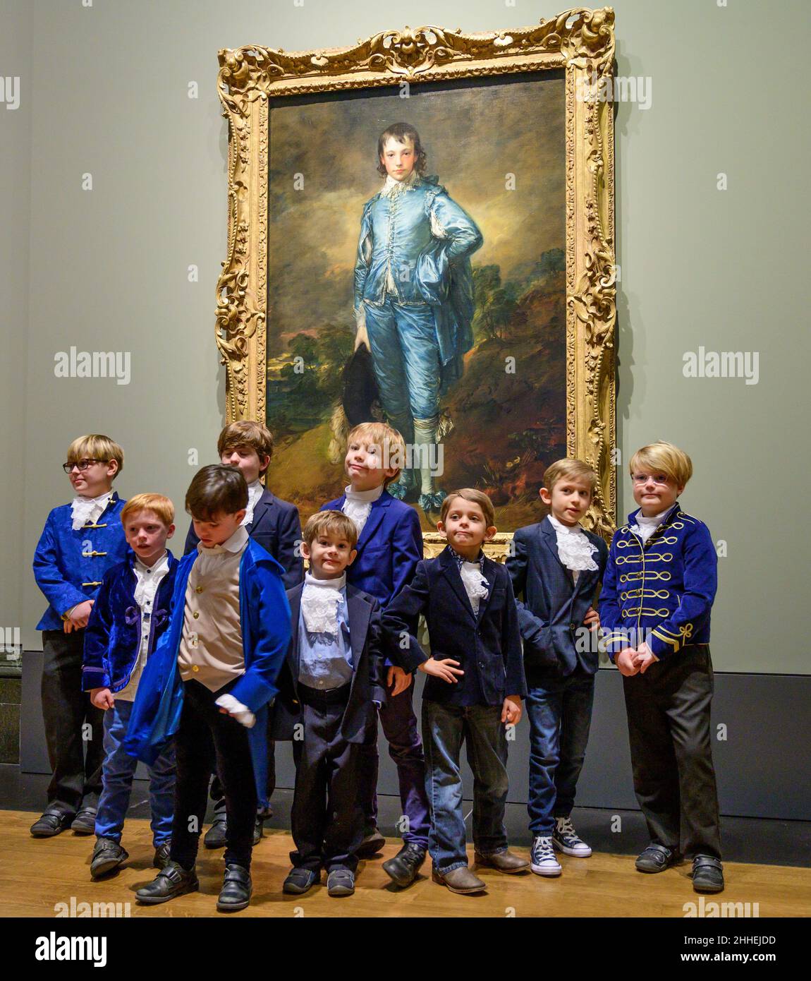 The National Gallery, London, Großbritannien. 24. Januar 2022. ‘The Blue Boy’, 1770, von Thomas Gainsborough wird zum 100th. Jahrestag seiner letzten Präsentation in Großbritannien in der National Gallery ausgestellt. Das Werk ist heute im Besitz der Huntington Library, des Art Museums und des Botanischen Gartens in San Marino, Kalifornien, wo es seit dem letzten Jahrhundert ausgestellt wird. Eine Gruppe ‘blauer Jungen’, Kinder von Mitarbeitern der National Gallery und der US-Botschaft in London, posieren vor dem Gemälde, alle in Blautönen gekleidet mit Kravatten, die der Figur auf dem Gemälde ähneln. Quelle: Malcolm Park/Alamy Live News. Stockfoto