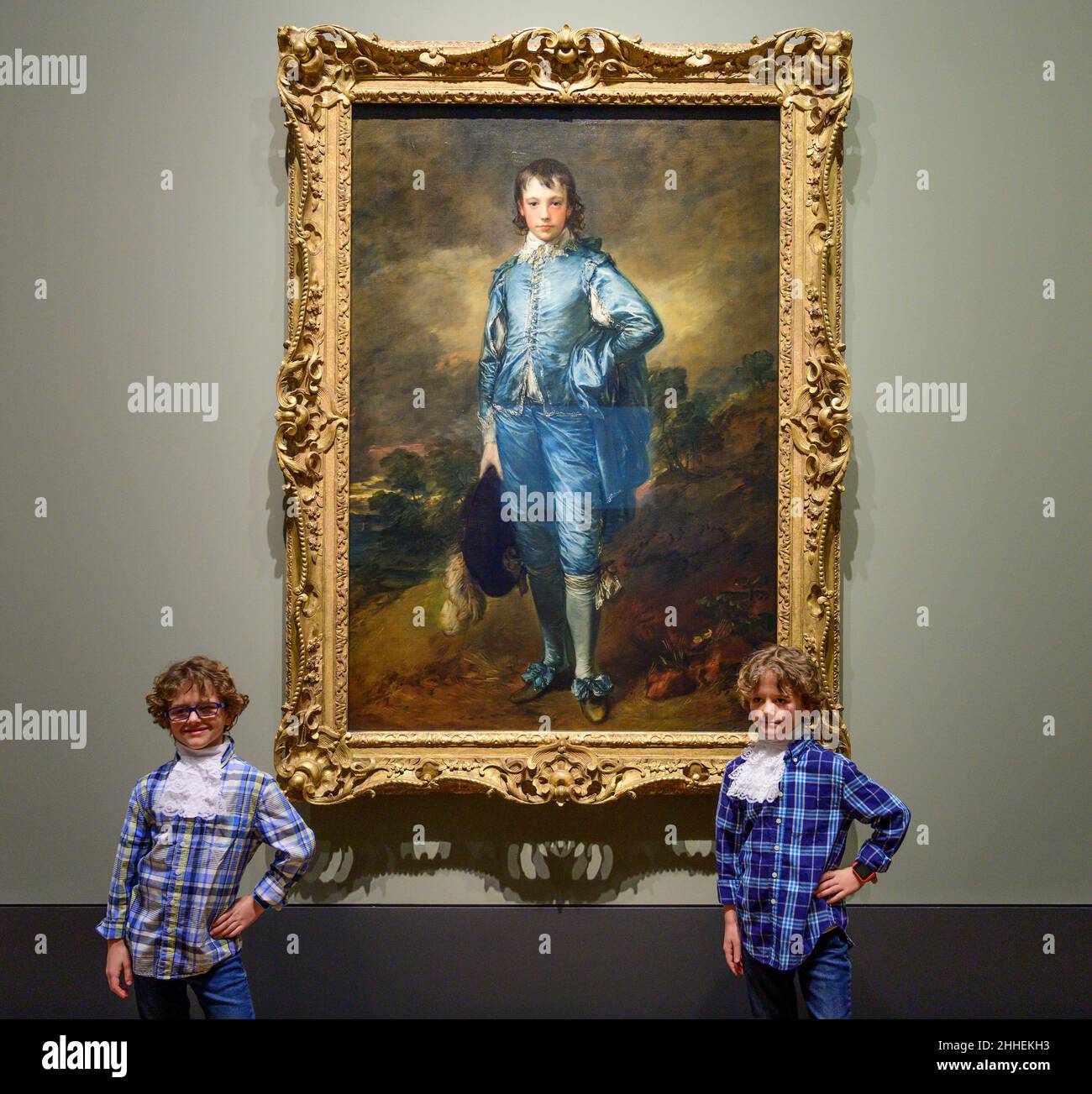 The National Gallery, London, Großbritannien. 24. Januar 2022. ‘The Blue Boy’, 1770, von Thomas Gainsborough wird zum 100th. Jahrestag seiner letzten Präsentation in Großbritannien in der National Gallery ausgestellt. Das Werk ist heute im Besitz der Huntington Library, des Art Museums und des Botanischen Gartens in San Marino, Kalifornien, wo es seit dem letzten Jahrhundert ausgestellt wird. Eine Gruppe ‘blauer Jungen’, Kinder von Mitarbeitern der National Gallery und der US-Botschaft in London, posieren vor dem Gemälde, alle in Blautönen gekleidet mit Kravatten, die der Figur auf dem Gemälde ähneln. Quelle: Malcolm Park/Alamy Live News. Stockfoto