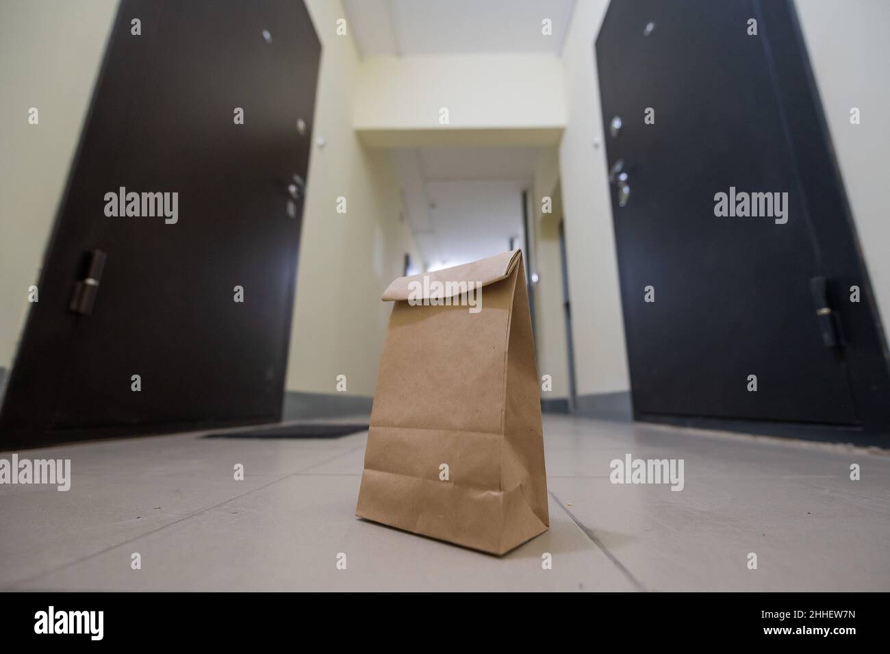 In der Lobby vor der Haustür der Wohnung steht eine Öko-Papiertüte. Kontaktlose Lebensmittelversorgung für die Epidemie. Der Kurier hat ein Online-Formular verlassen Stockfoto