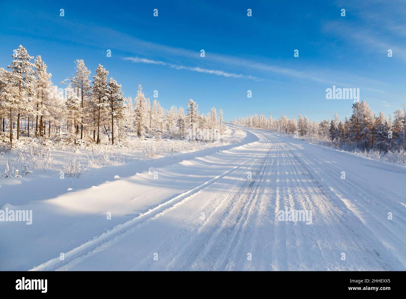 Straße im Winterwald an einem sonnigen Tag. Südjakutien, Russland Stockfoto
