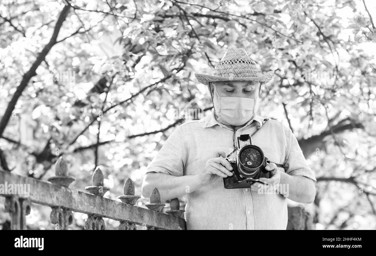 Professioneller Fotograf arbeiten während Coronavirus Quarantäne. Mann Tourist verwenden Kamera nehmen Foto von Kirschblüte. sakura in voller Blüte Fotografie Stockfoto