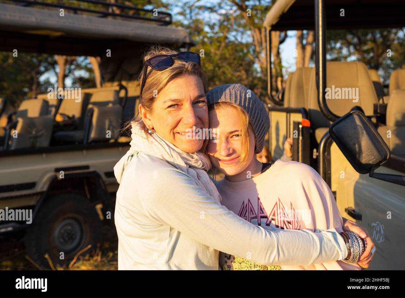 Eine Mutter umarmt ihre Tochter im Teenageralter auf einer Familiensafari. Stockfoto