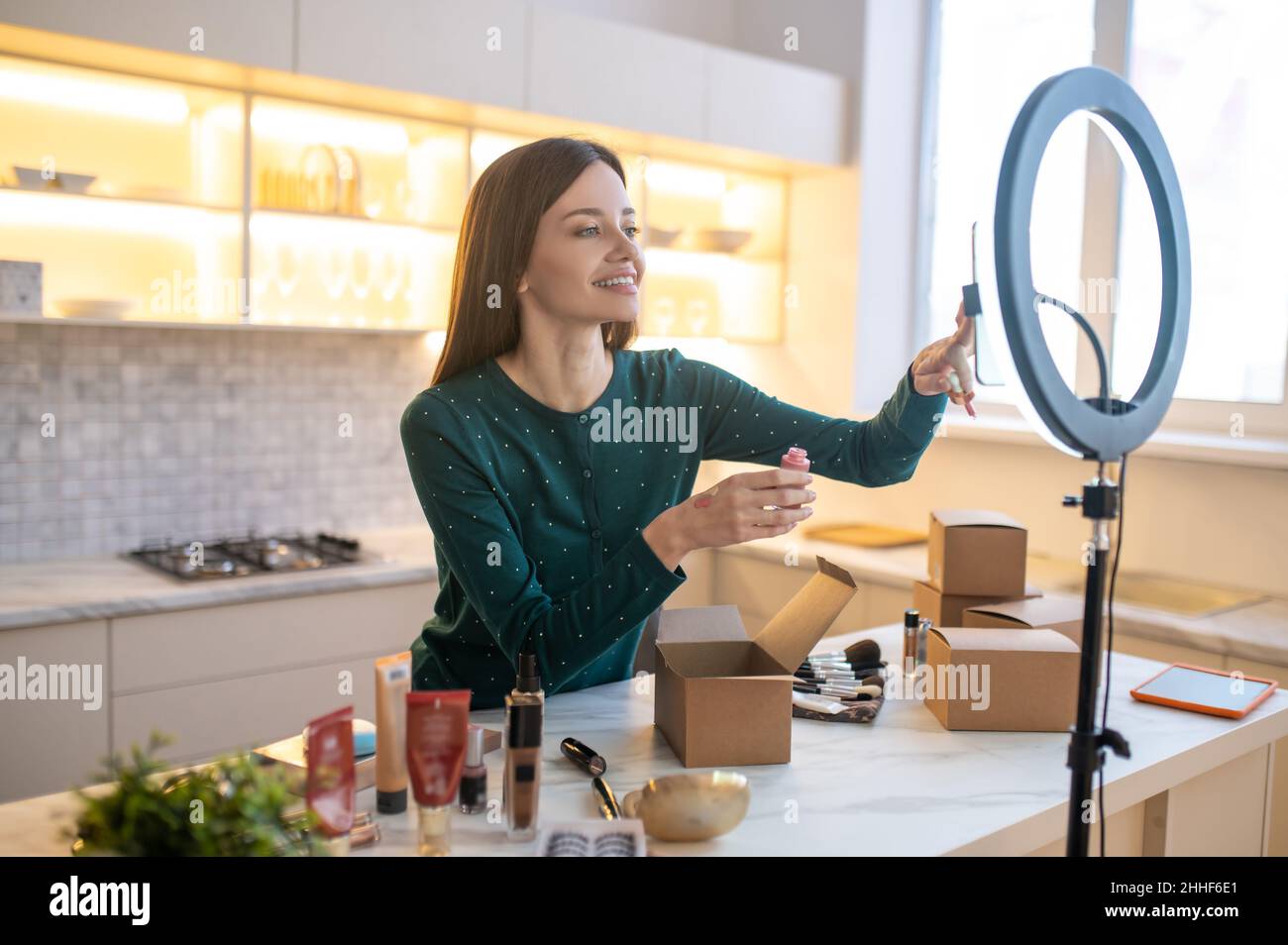 Junge Frau, die eine Probe der neuen Tonungscreme auf ihre Hand aufgibt Stockfoto