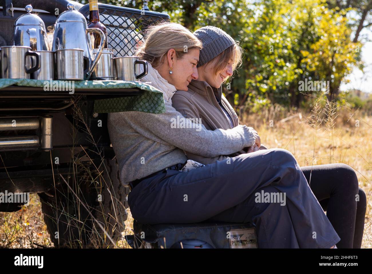 Eine Frau und ihre Tochter im Teenageralter sitzen an einem Jeep Stockfoto