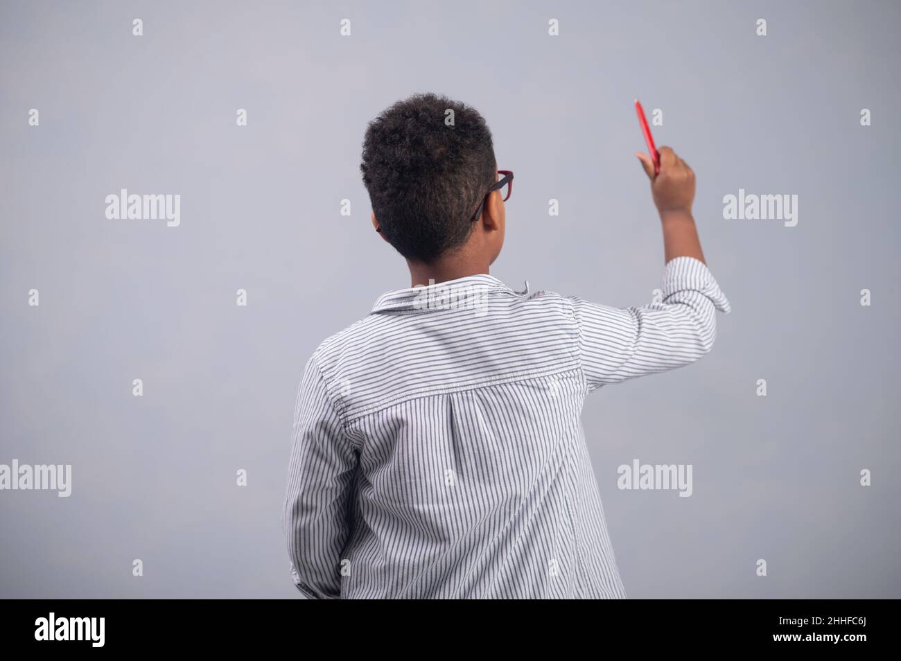 Bebrilltes afroamerikanisches Kind, das eine Skizze macht Stockfoto