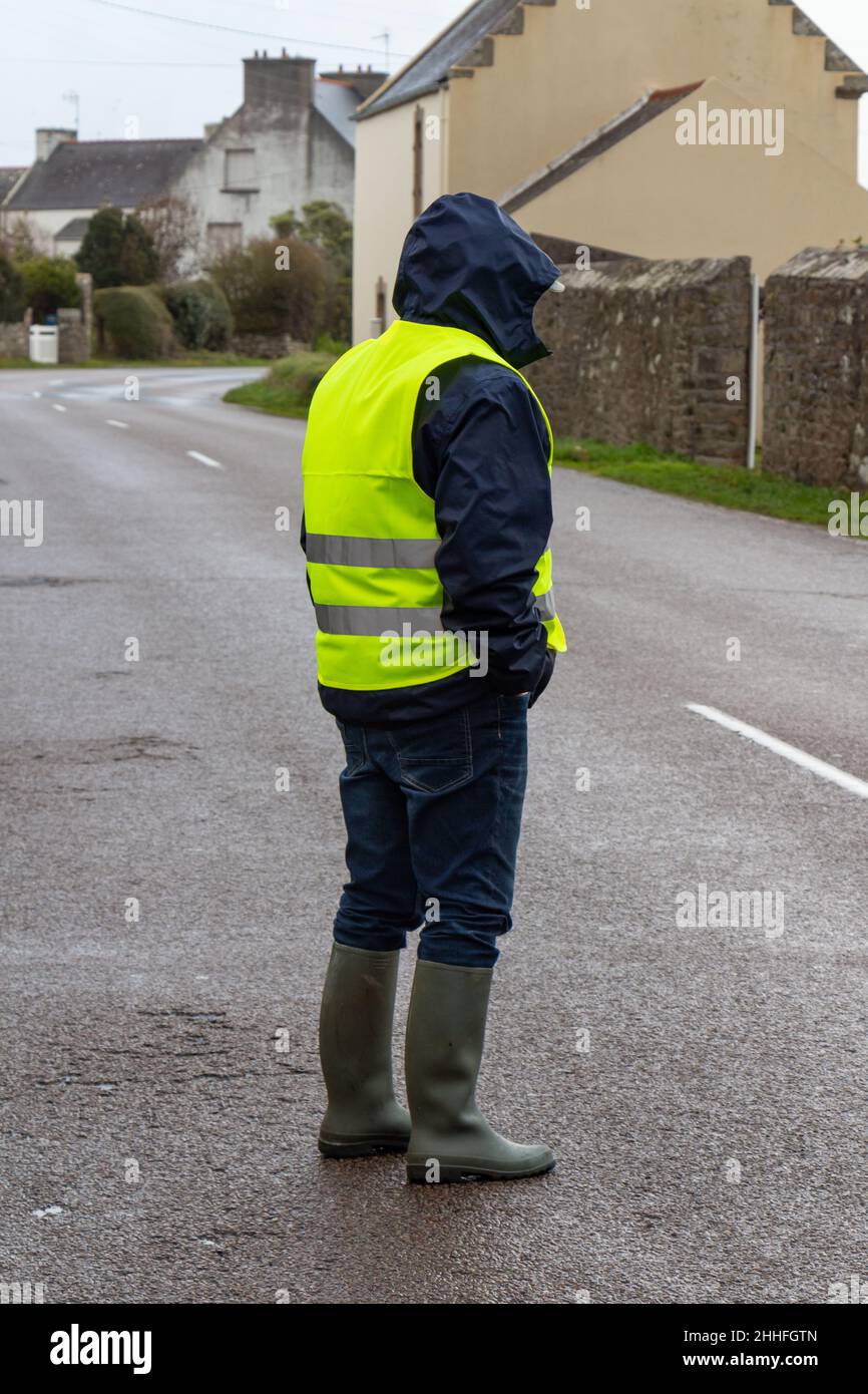 Mann mit gelber Weste auf der Straße Stockfoto