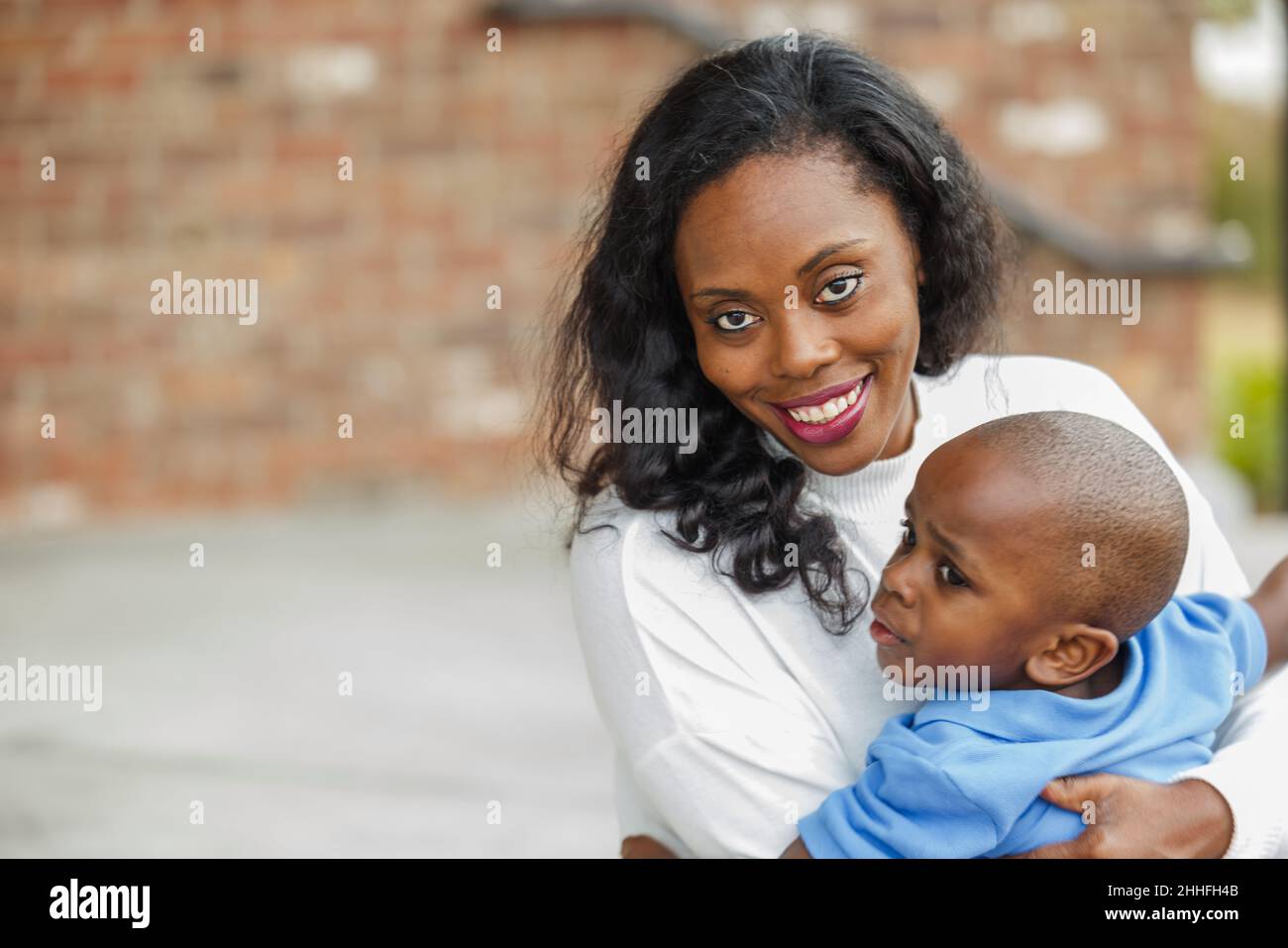 Eine wunderschöne afroamerikanische Mutter, die ihren Sohn im Vorschulalter umarmt Stockfoto