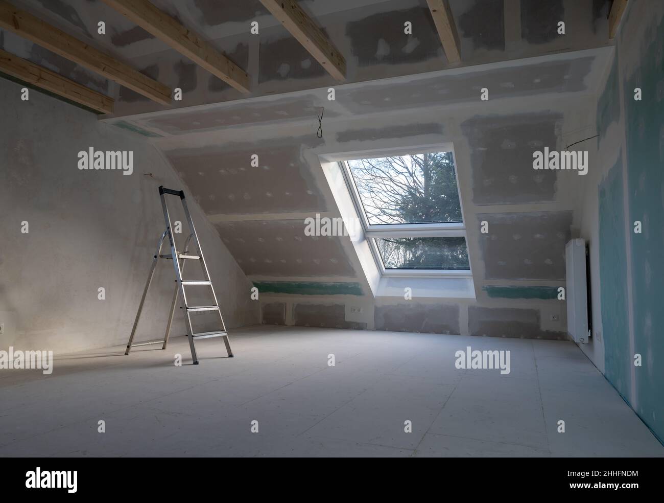 Trockenbauverputzung während einer Hausrenovierung im Dachgeschoss. Stockfoto