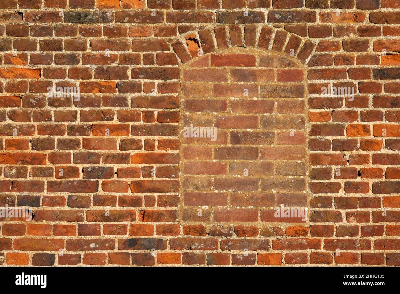 Eine Wohnung auf einem Bereich mit antiken roten Ziegelwänden mit einem gefüllten Fenster Stockfoto