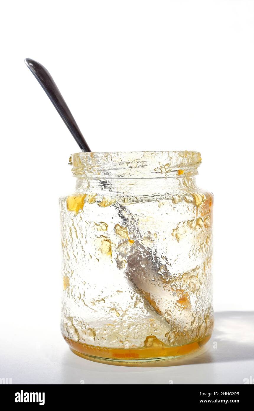 Leeres Glas Marmeladenglas mit Löffel auf weißem Hintergrund Stockfoto