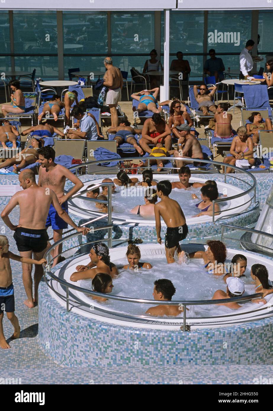 Passagiere auf dem Sonnendeck des Schwimmbades eines Kreuzschiffs Stockfoto