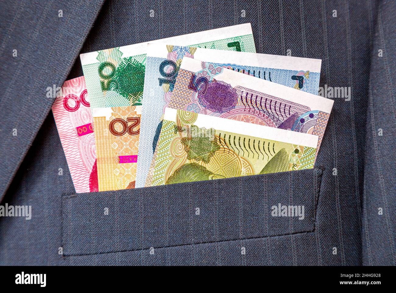 Banknoten der chinesischen Währung in der Tasche des Geschäftsmannes. Geld in der Tasche des Business-Anzugs Stockfoto