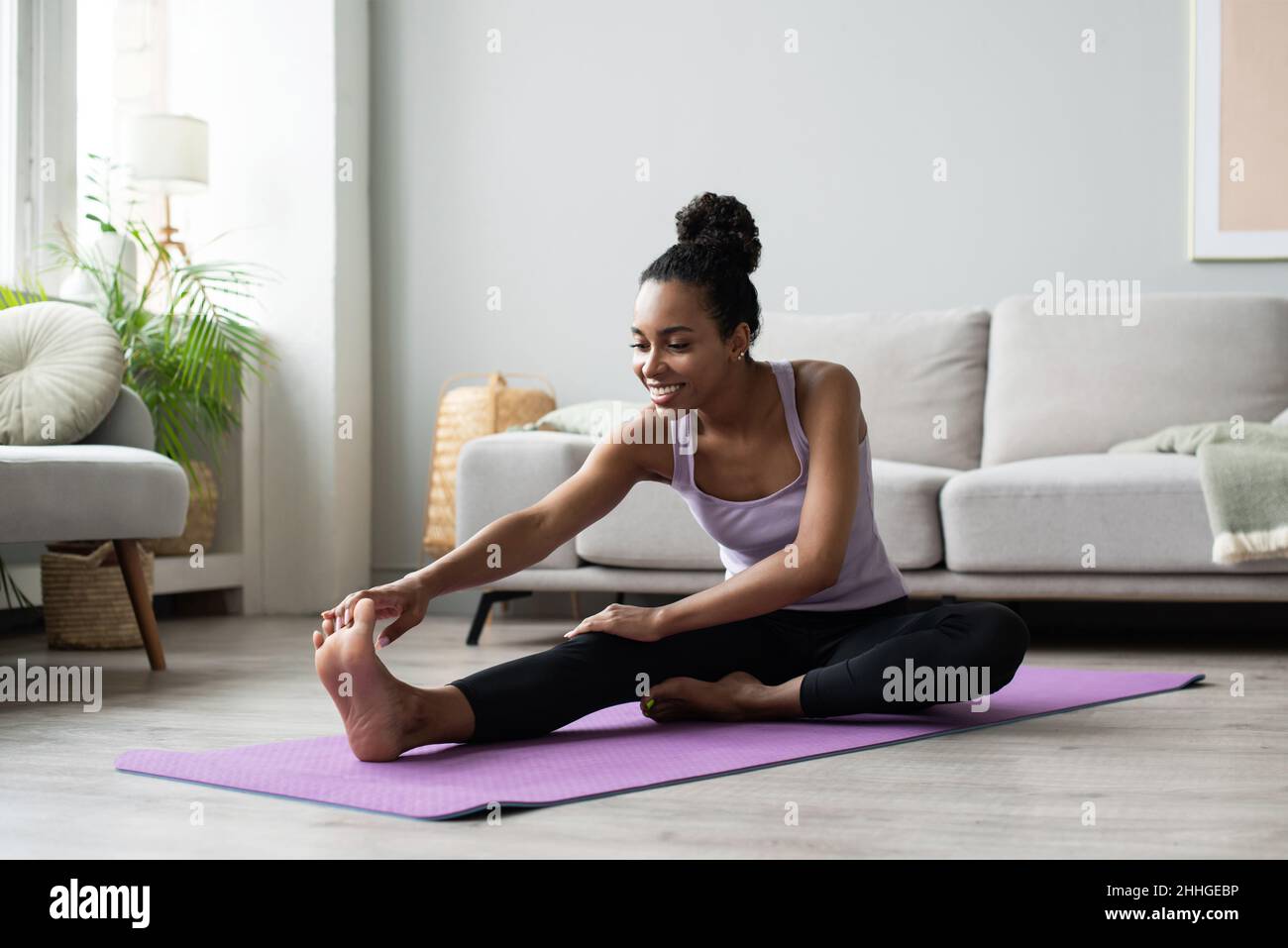 Frau macht Fitness-Übungen zu Hause. afroamerikanische Mädchen, die in ihrem Zimmer trainiert. Training, Fitness, Workout, aktives Lifestyle-Konzept Stockfoto