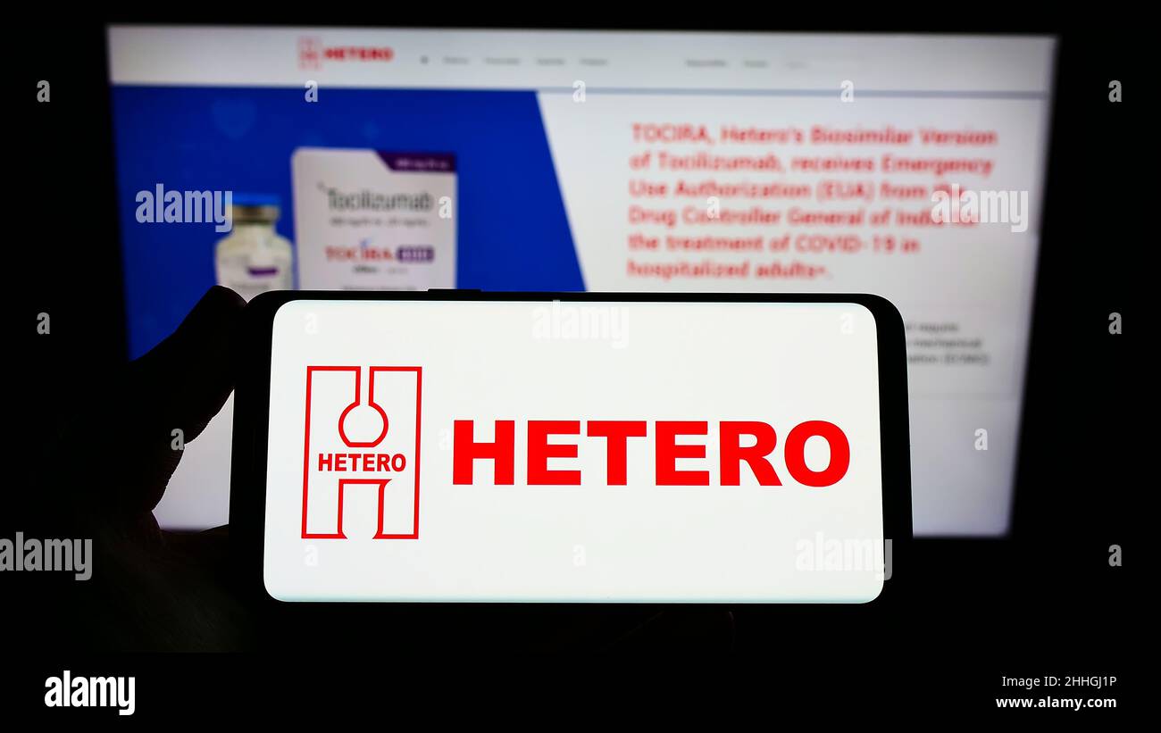 Person, die das Smartphone mit dem Logo des indischen Pharmaunternehmens Hetero Group auf dem Bildschirm vor der Website hält. Konzentrieren Sie sich auf die Telefonanzeige. Stockfoto