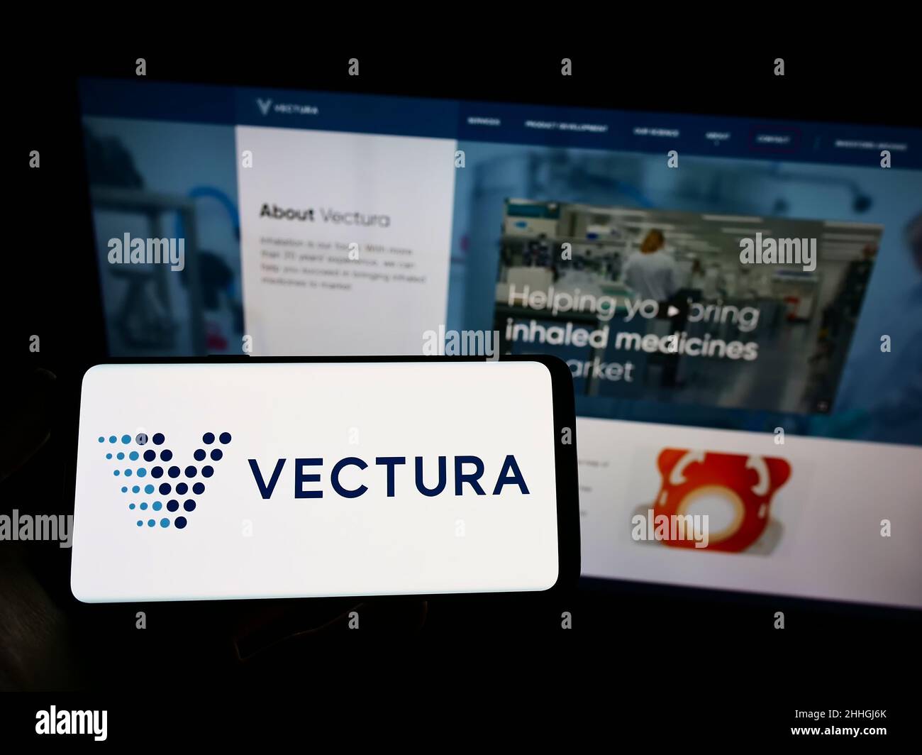 Person, die das Smartphone mit dem Logo des britischen Pharmaunternehmens Vectura Group plc auf dem Bildschirm vor der Website hält. Konzentrieren Sie sich auf die Telefonanzeige. Stockfoto
