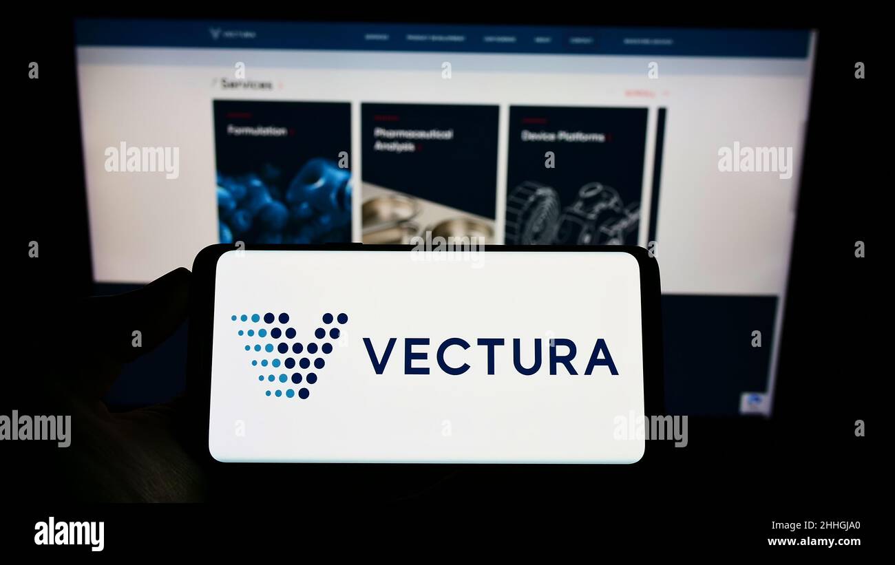 Person mit Mobiltelefon und Logo des britischen Pharmaunternehmens Vectura Group plc auf dem Bildschirm vor der Webseite. Konzentrieren Sie sich auf die Telefonanzeige. Stockfoto