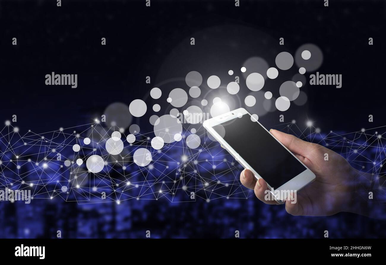 Innovative und globale Netzwerkverbindung, Datenaustausch. Hand halten weißes Smartphone mit digitalen Hologramm Daten Kreise Zeichen auf Stadt dunkel verschwommen Bac Stockfoto