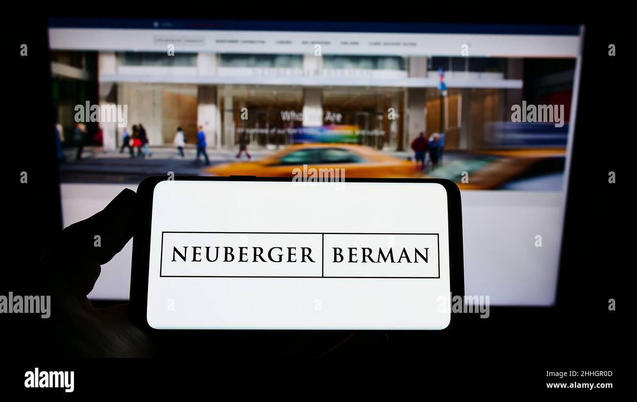 Person, die Smartphone mit dem Logo der US-Investmentgesellschaft Neuberger Berman Group LLC auf dem Bildschirm vor der Website hält. Konzentrieren Sie sich auf die Telefonanzeige. Stockfoto