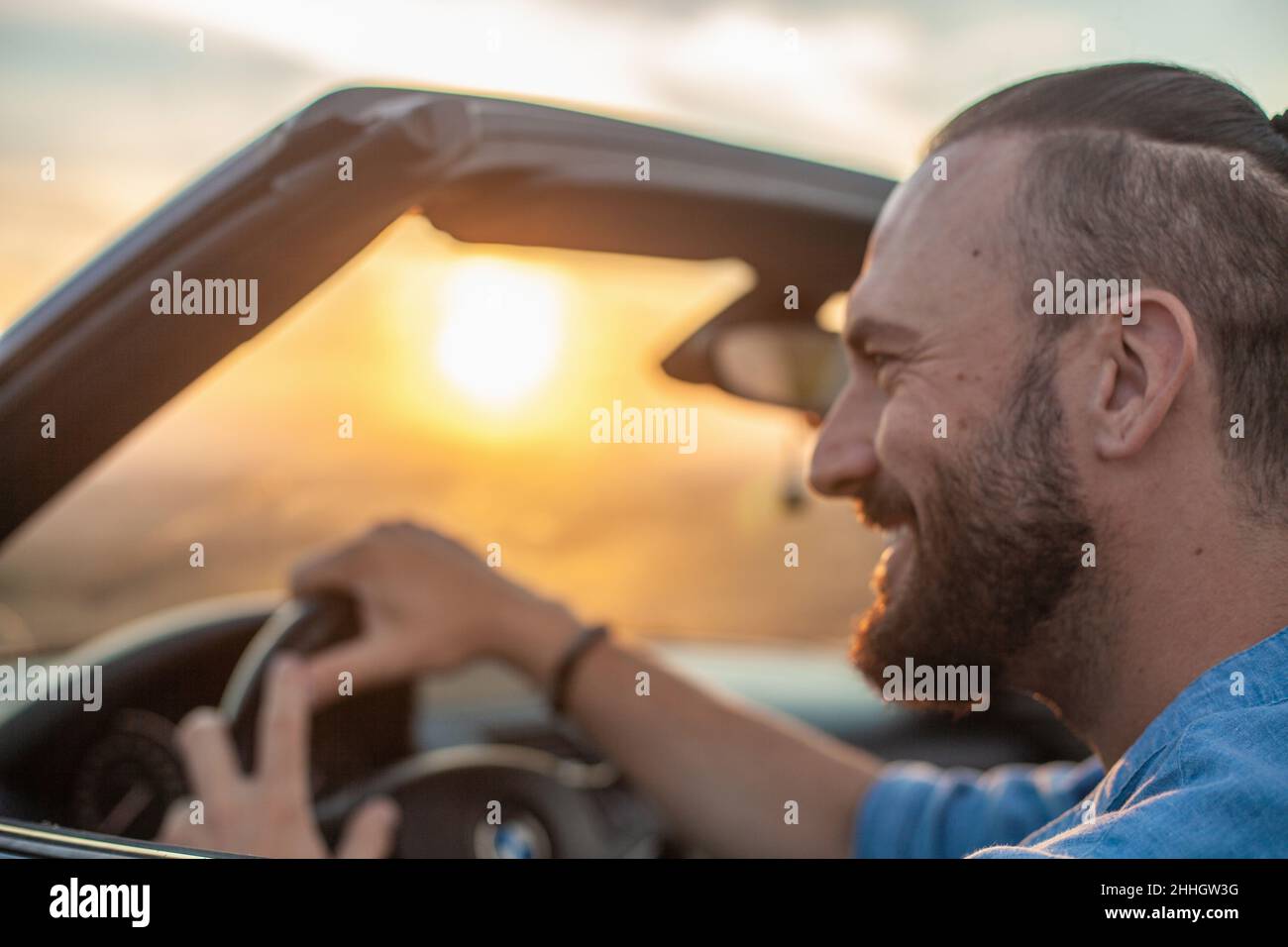 Lächelnder Mann, der Cabriolet in der Landschaft fährt Stockfoto