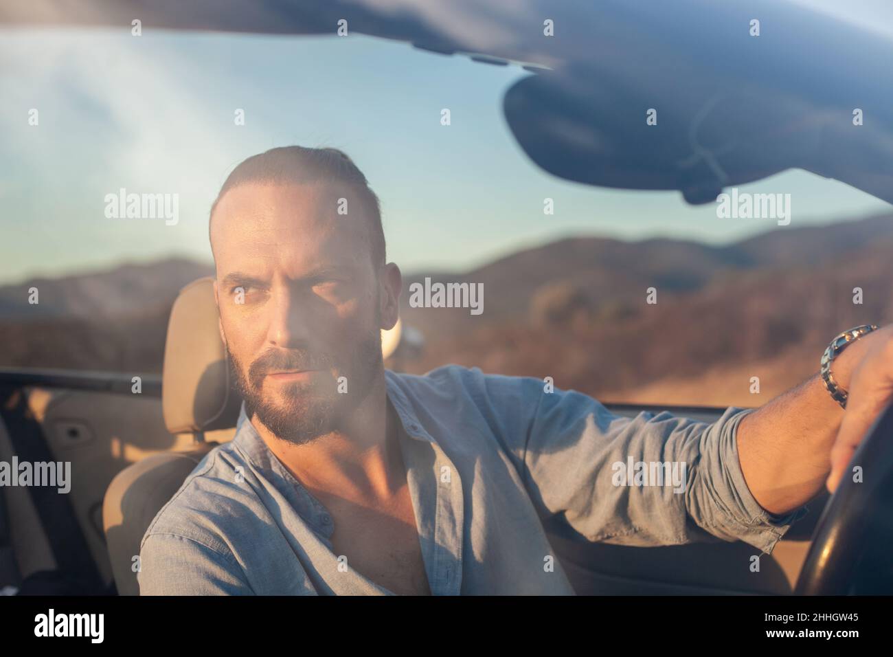 Mann fährt Cabrio Auto in der Landschaft Stockfoto