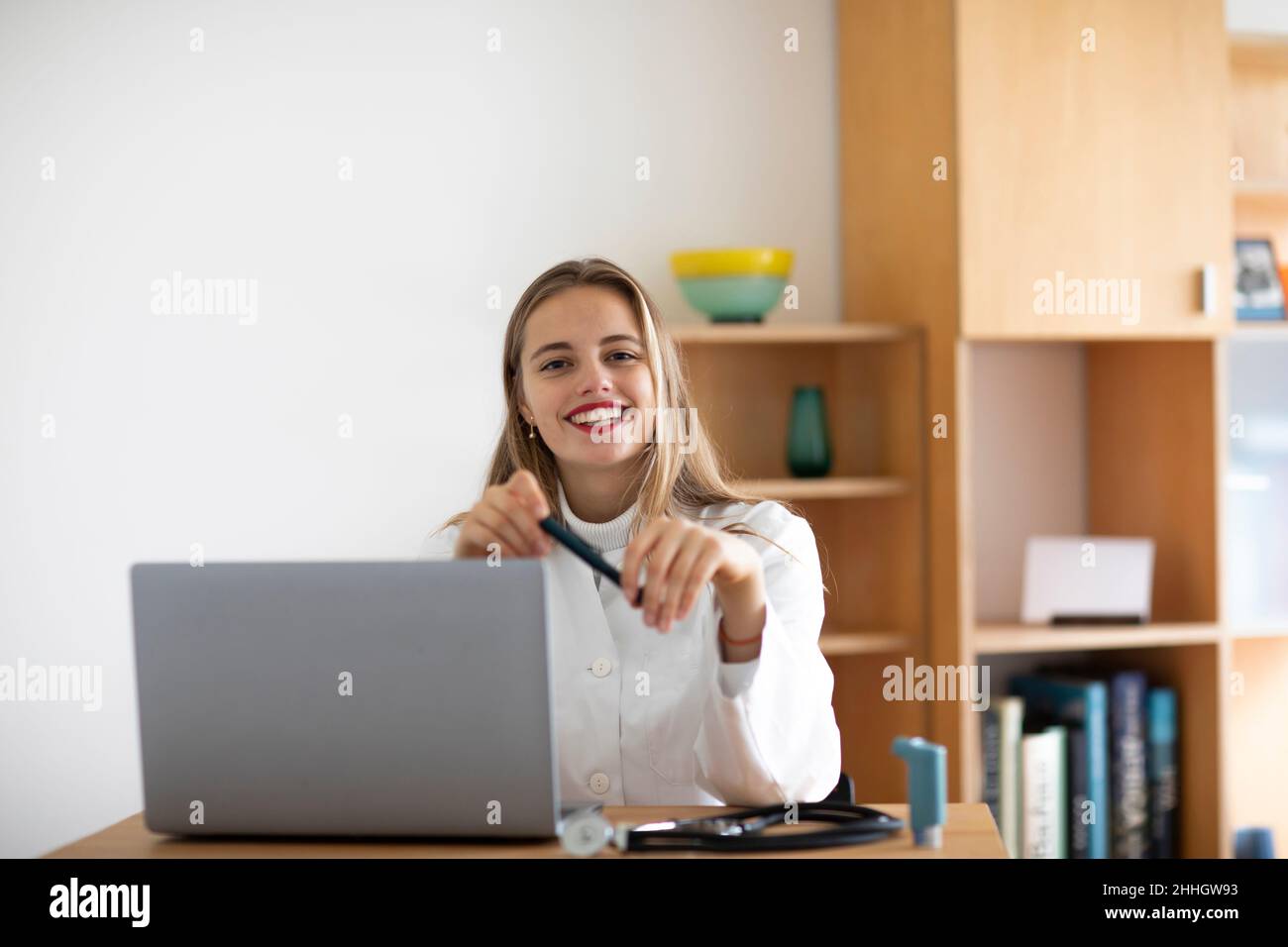 Porträt einer lächelnden jungen Ärztin mit Laptop Stockfoto