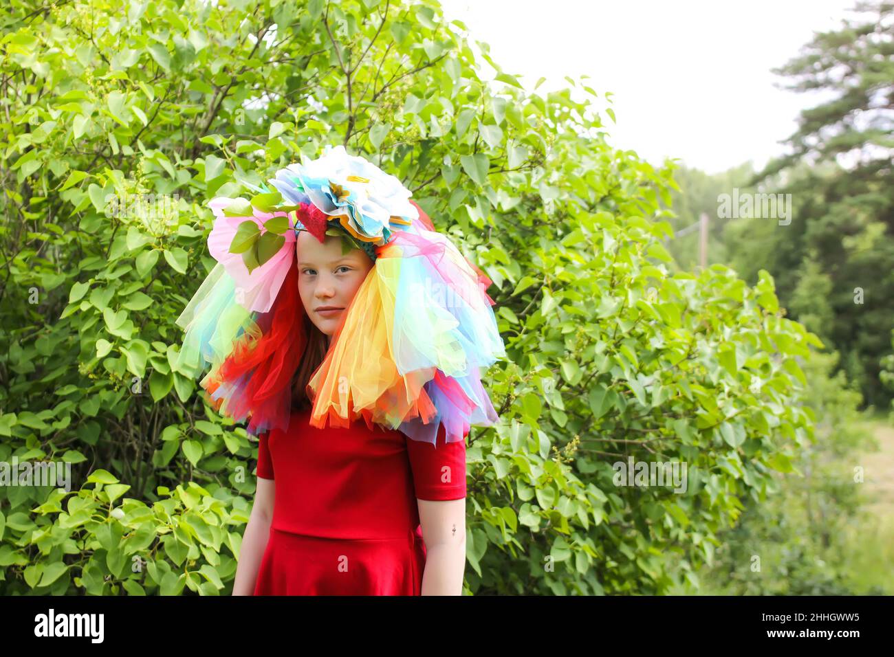 Liebenswert Mädchen in bunten Regenbogen Kleid auf ihrem Kopf spielen im Freien Stockfoto