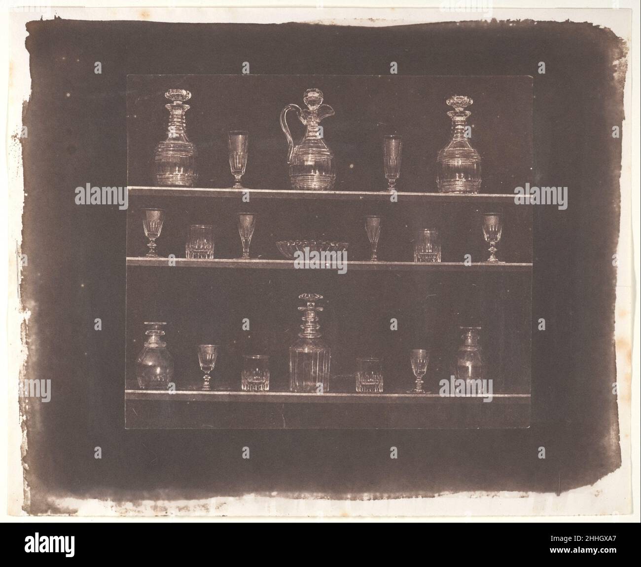 Glasartikel vor dem 1844. Juni William Henry Fox Talbot britische Stillleben-Maler haben häufig geschliffene Kristalle oder Glaswaren in ihre aufwendigen Frucht- oder Blumenkompositionen aufgenommen (53,111), zum Teil als Demonstration virtuoser Techniken, um ein transparentes Objekt zu malen, das nur als reflektiertes und gebrochenes Licht sichtbar ist, Stellt eine besondere Herausforderung dar und bringt, wenn erfolgreich, besondere Freude an den Betrachter. Talbot scheint auf der Platte 4 des Bleistiftes der Natur zu sagen: "Schau dir an, was das neue Medium der Fotografie dir geben kann – nicht nur einen Kristallkelch, sondern Regale voller Glas, so mühelos wie es ist Stockfoto