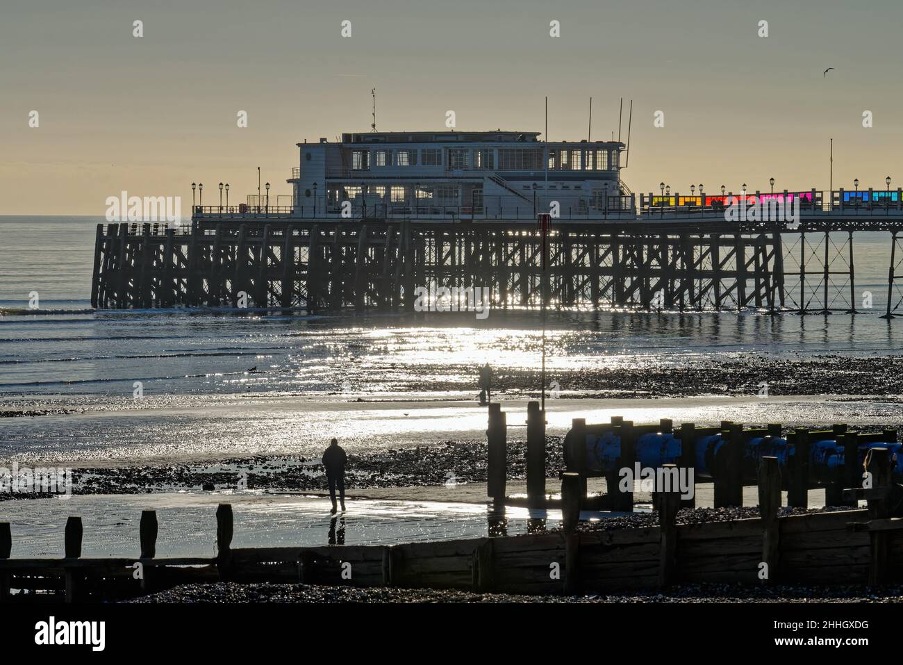 Worthing Pier und Strand bei Sonnenuntergang an einem kalten Wintertag West Sussex England Großbritannien Stockfoto