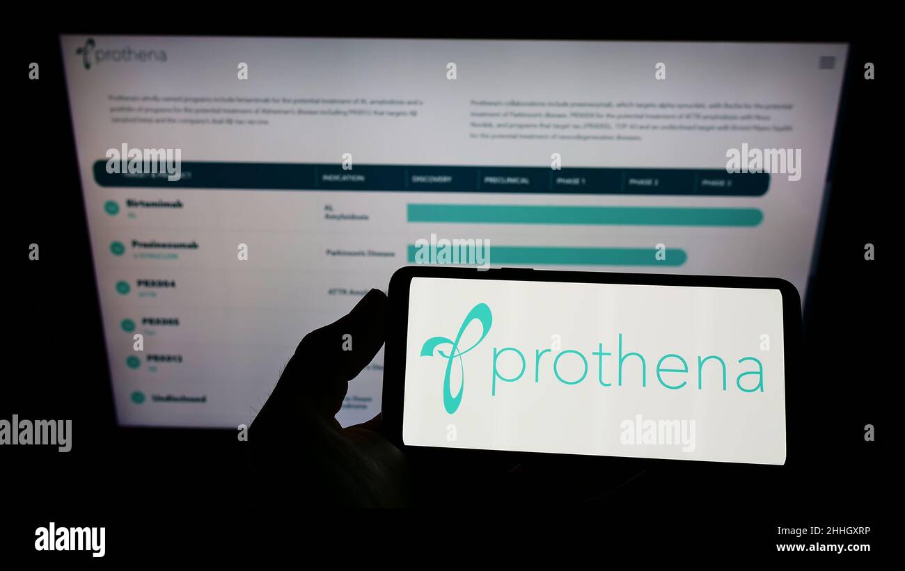Person, die das Smartphone mit dem Logo des Biotechnologie-Unternehmens Prothena Corporation plc auf dem Bildschirm vor der Website hält. Konzentrieren Sie sich auf die Telefonanzeige. Stockfoto