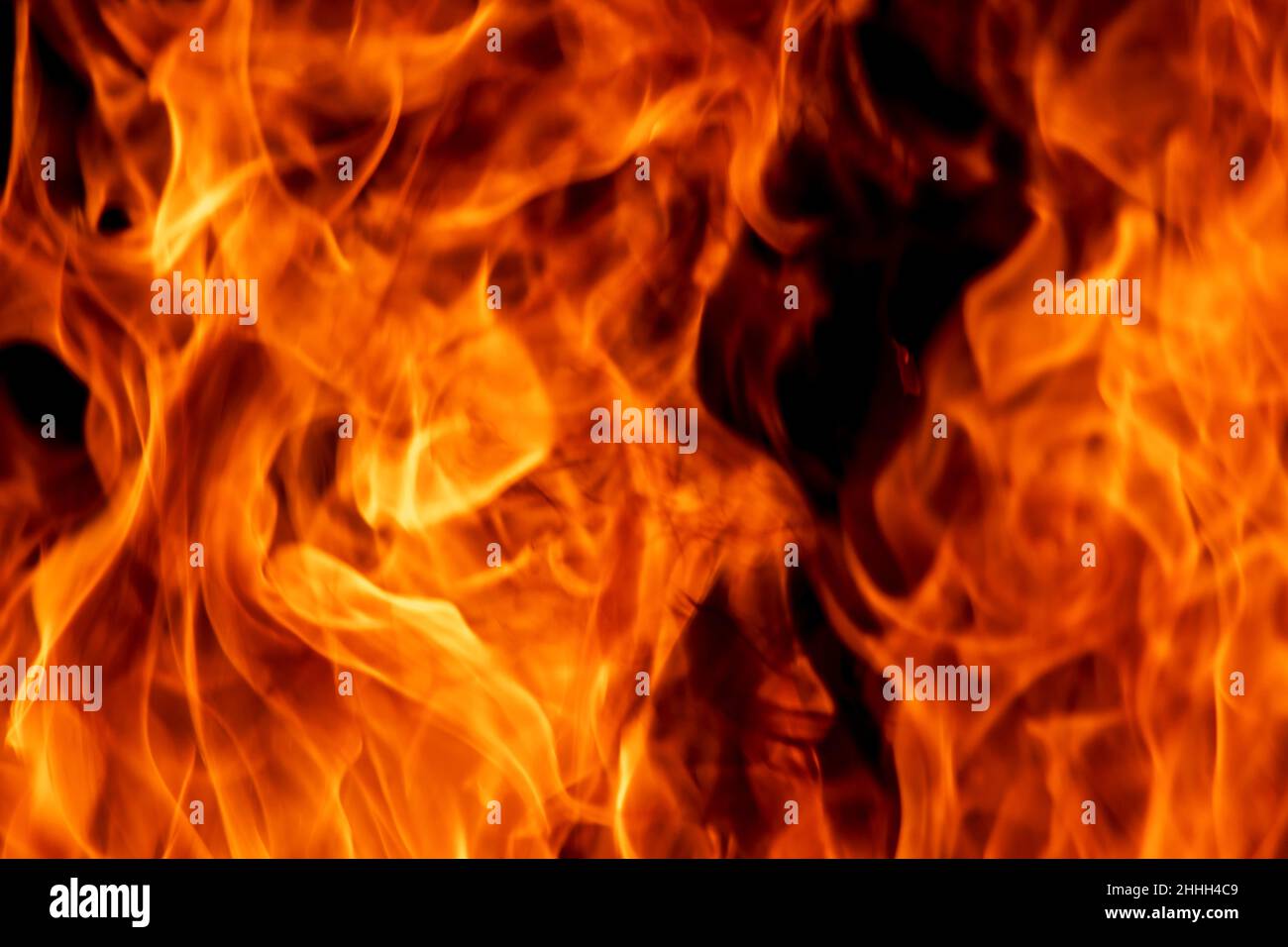 Abstrakte Flamme, Feuerflammenstruktur, Hintergrund. Verschwommene, sich bewegende Feuerzungen auf dunklem Hintergrund. Stockfoto