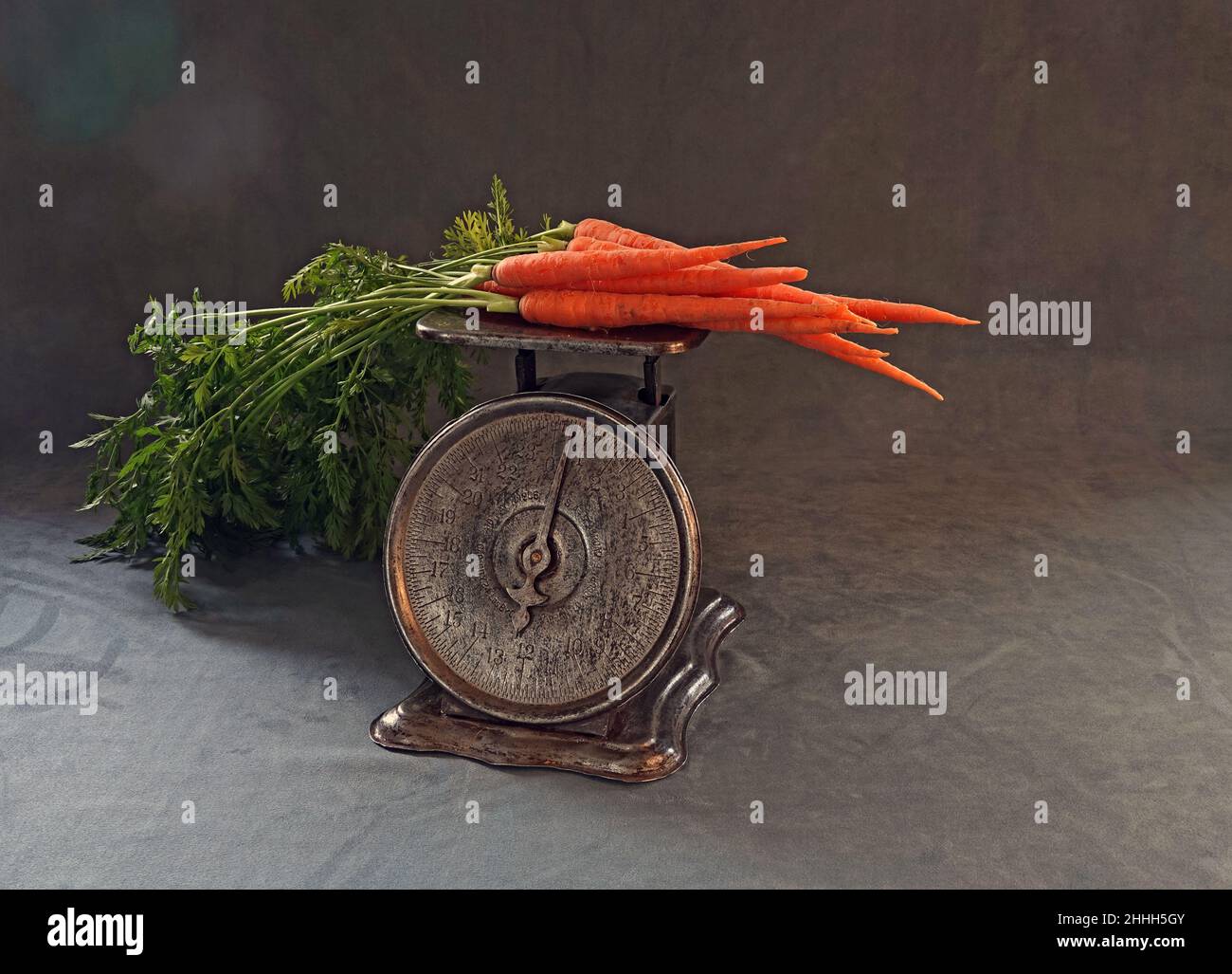 Porträt einer Vintage-Küchenwaage mit einem bunten Strauß Bio-Karotten. Stockfoto