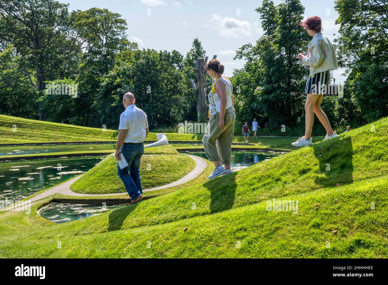 Besucher genießen Cells of Life von Charles Jencks im Jupiter Artland Outdoor Skulpturenpark in der Nähe von Edinburgh. Stockfoto