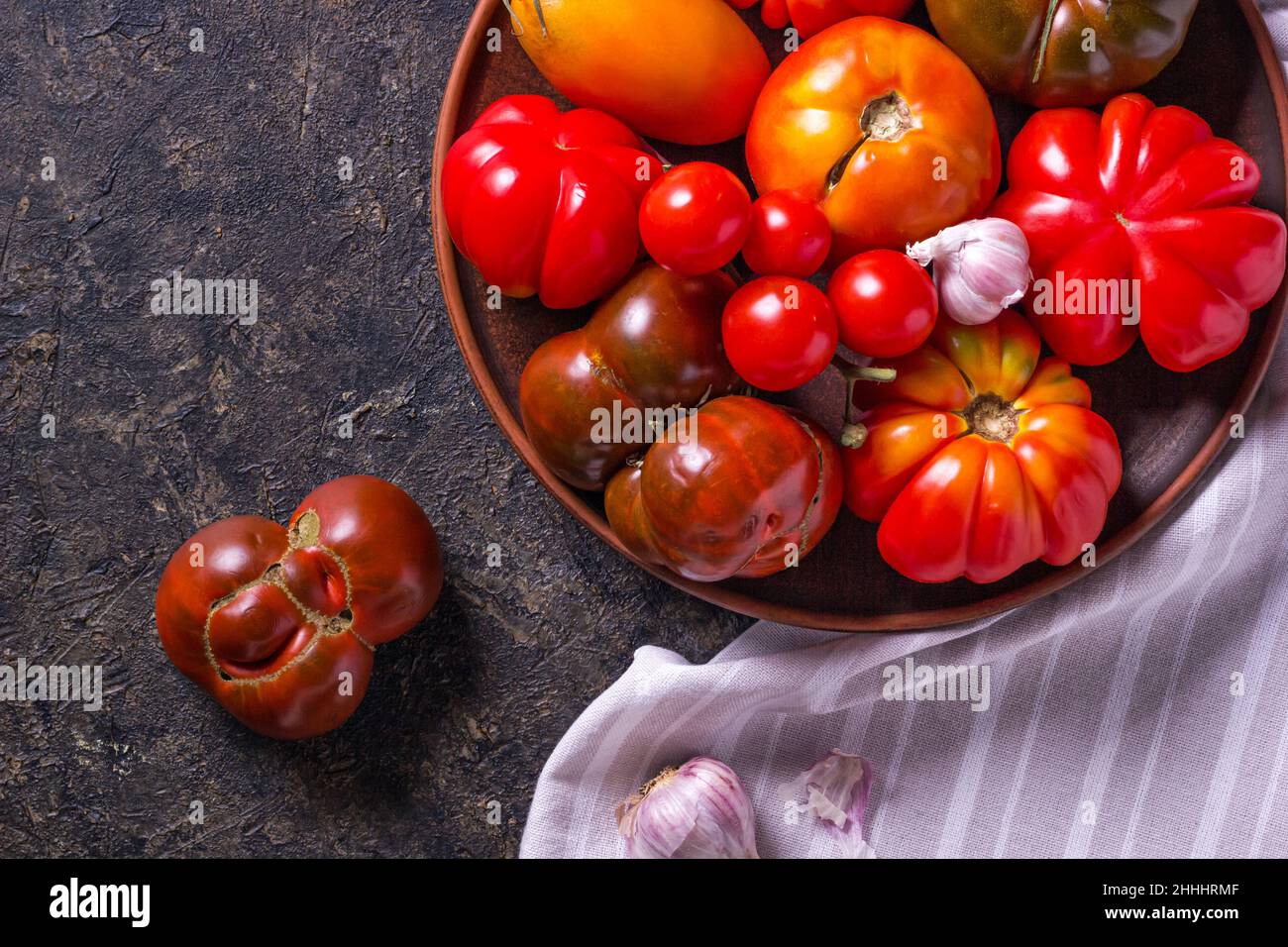 Die Ernte von verschiedenen Tomaten. Bunte Bio-Tomaten auf einem großen Teller. Tomaten verschiedene Sorten. Draufsicht Stockfoto