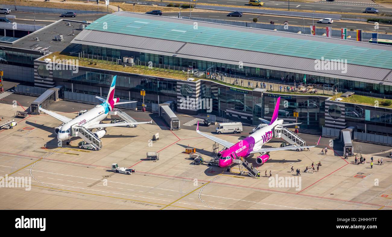 Luftaufnahme, Flughafen Dortmund mit Empfangsgebäude und Terminalgebäude, 2 Flugzeuge von Eurowings und Wizz Air, Dortmund, Nordrhein-Westfalen, Deutschland Stockfoto