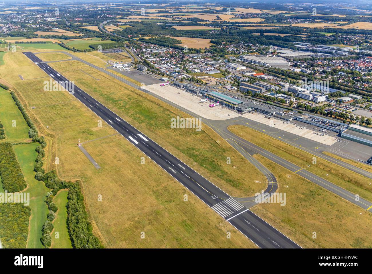 Luftaufnahme, Flughafen Dortmund mit Empfangsgebäude und Terminalgebäude, Start- und Landebahn, 2 Flugzeuge von Eurowings und Wizz Air, Dortmund, Nordrhein-Westfalen Stockfoto