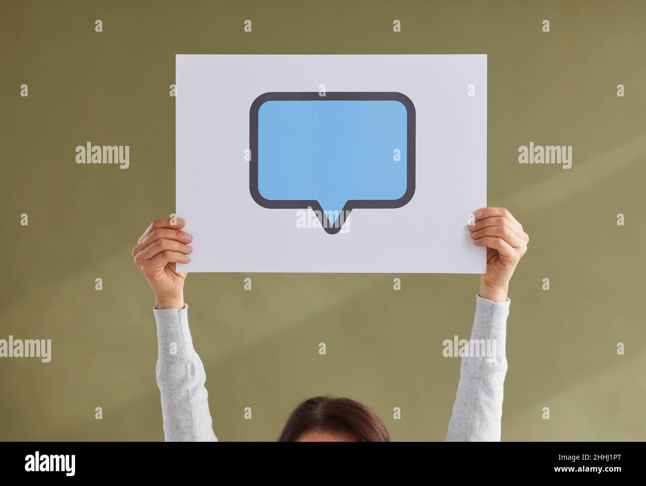 Papierkarte mit blauem Kopierraum Sprechballon oder Nachrichtenblase in den Händen der Frau Stockfoto