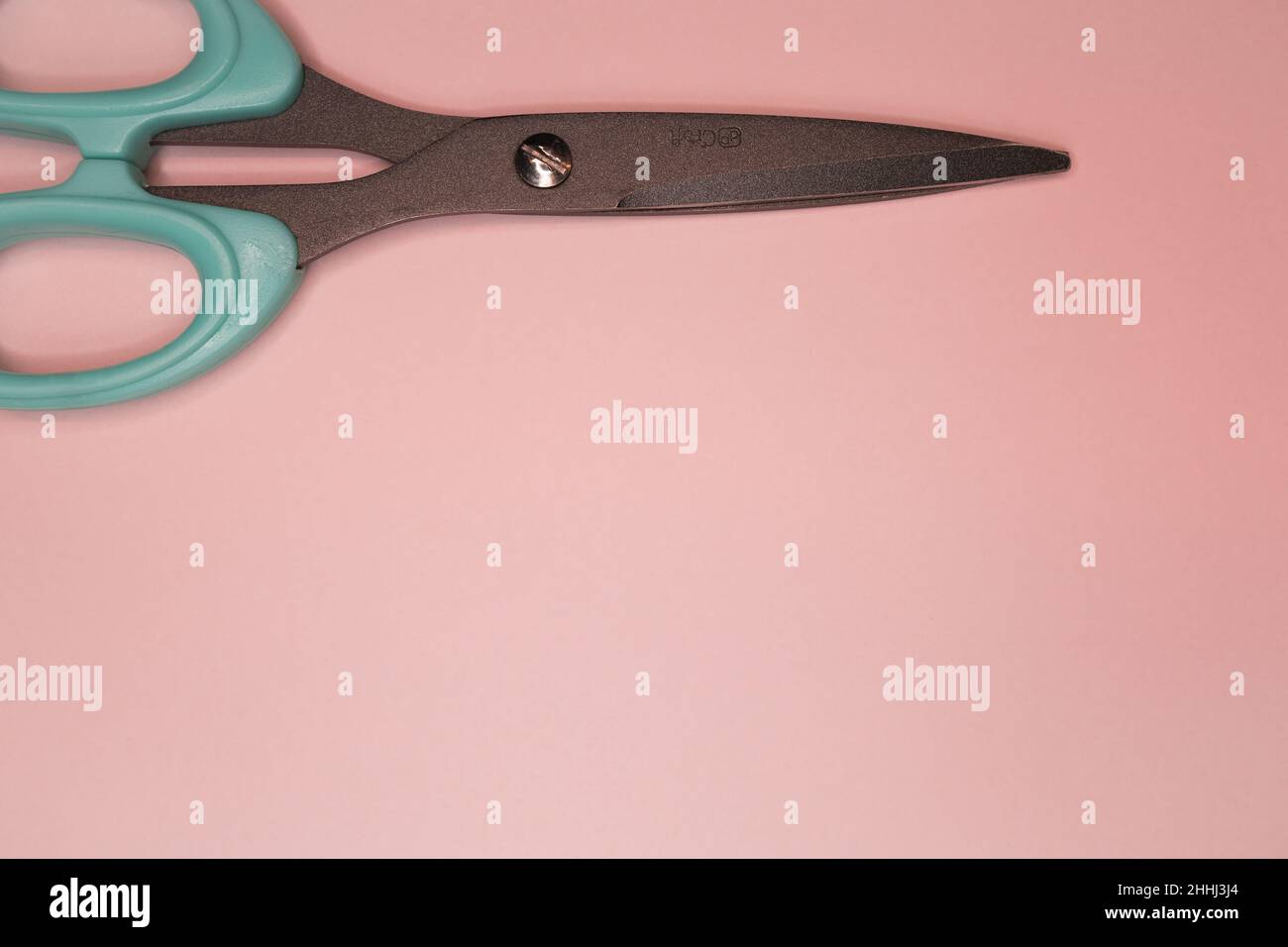 Teal Schere auf hellrosa Hintergrund Stockfoto