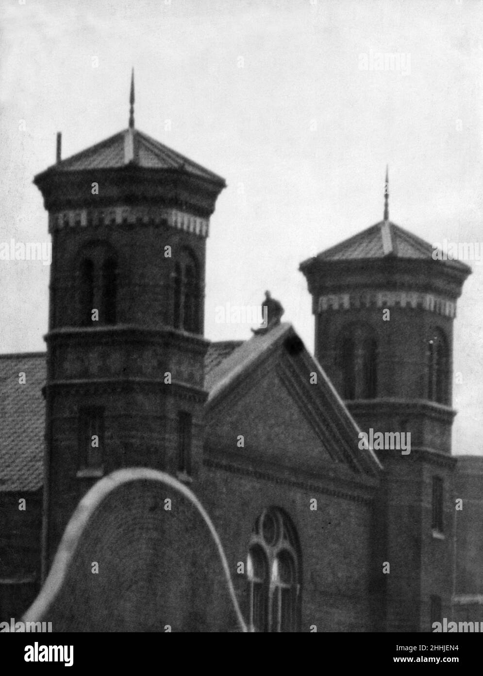 Convict C23 auf dem Dach von Wormwood scheuert sich. C23, ist ein Sträfling im Gefängnis von Wormwood Scrubs, brach er aus den Reihen und stieg auf das Dach. Fast fünf Stunden lang durchstreifte er die Fliesen, zerschlug Glas und beschädigte sie. Im Bild: C23 nach dem Einschlagen vieler Fenster eine kleine Pause genießen und sich vor einem weiteren Ansturm erholen. 6th. April 1907. Stockfoto