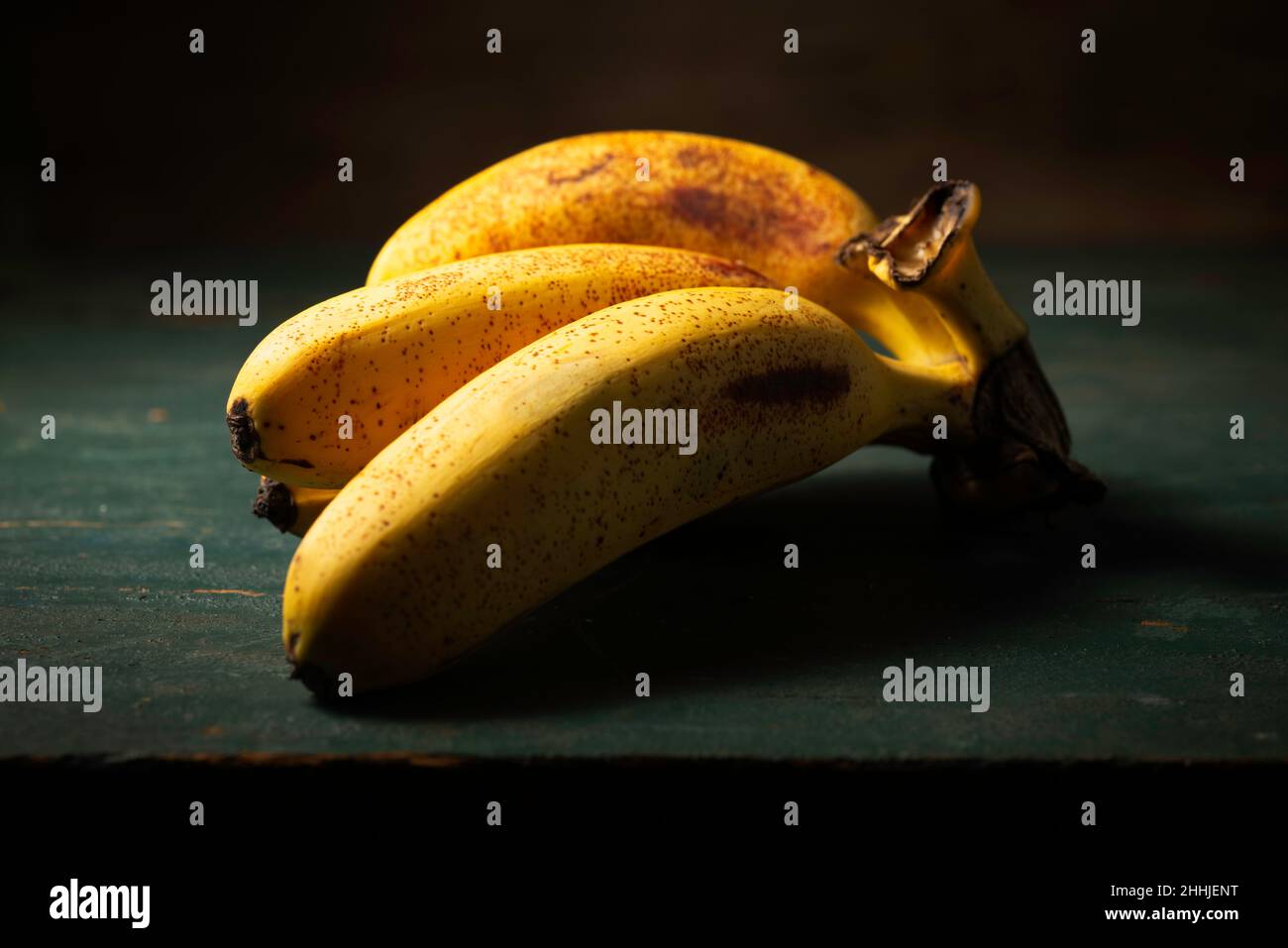 Bananenfrüchte auf einem Holztisch Stockfoto