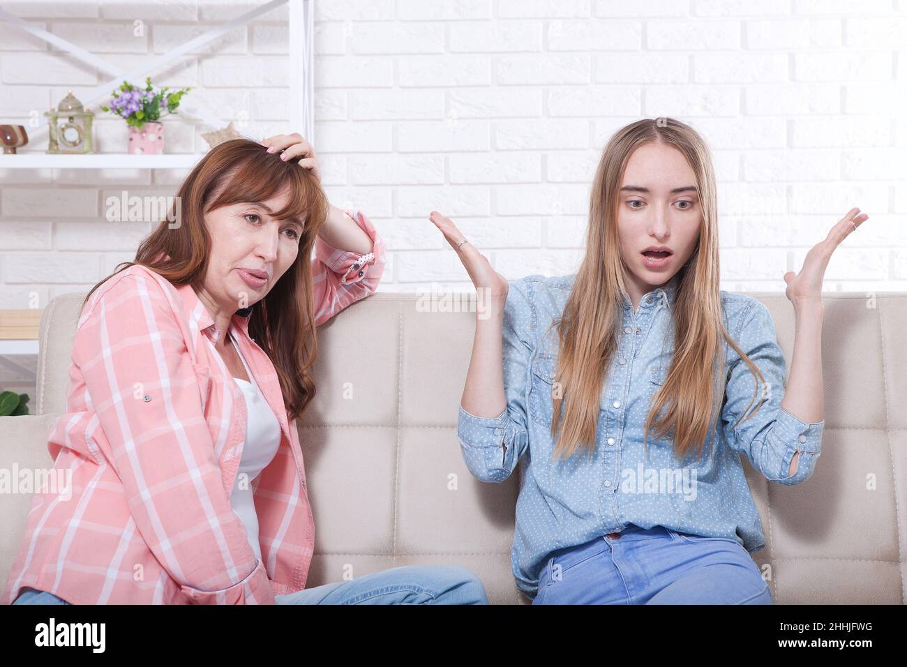 Frühe Schwangerschaft. Mutter und Tochter sitzen auf dem Sofa im Hintergrund zu Hause. Platz kopieren und Modell erstellen Stockfoto