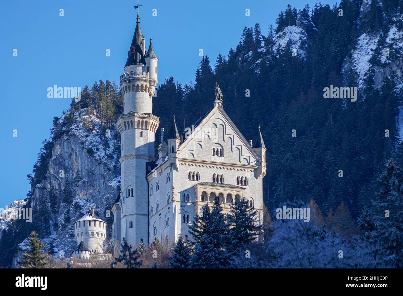 Blick im Winter vom Dorf Schwangau auf das königliche Schloss Neuschwanstein, umgeben von Wald in den Bergen, von König Ludwig II. Stockfoto